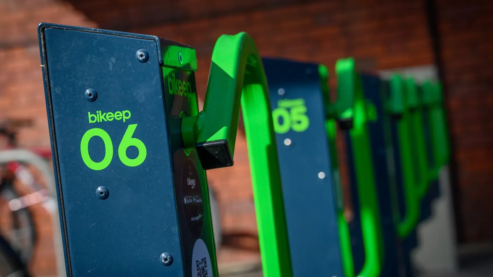Close-up of Bikeep e-bike charging dock 06 with its green locking bar at Bedford station