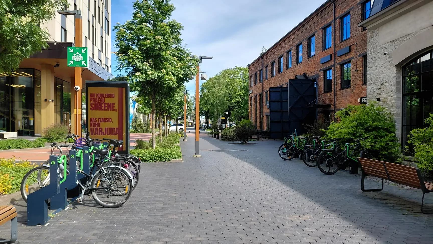 Bikeep smart bike parking stations with bikes docked on both sides of a pedestrian street at the Ülemiste City business campus in Tallinn